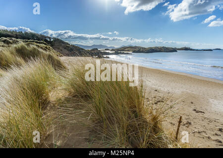 Una vista di Llanddwyn Island su Anglesey da dune di sabbia sulla spiaggia di Newborough. Foto Stock