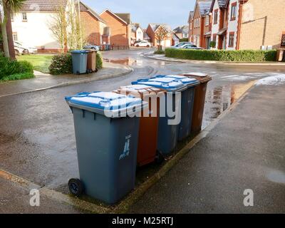 Cinque blu e marrone scomparti di riciclaggio schierate e fuori per la raccolta in un freddo snowy lunedì mattina in Kesgrave vicino a Ipswich, Suffolk. Febbraio 2018. Foto Stock