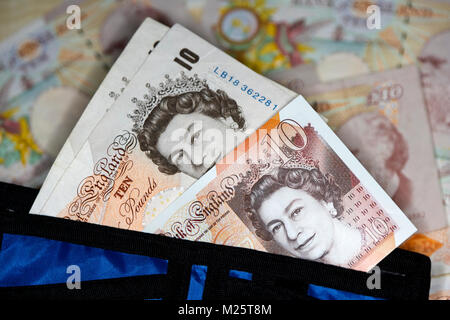 Nuovo polimero 10 quid note con presto ad essere gradualmente eliminato carta 10 pound note in un portafoglio nel Regno Unito Foto Stock