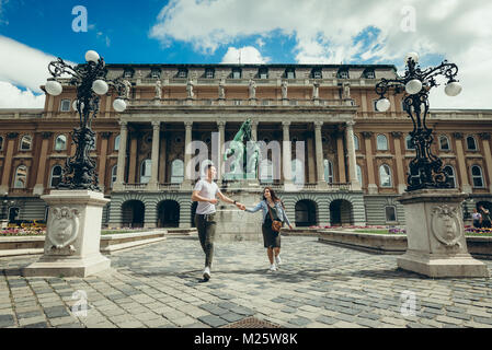 A piedi della graziosa amare giovane felicemente parlando e tenendo le mani nel countryard presso il Castello di Buda Royal Palace di Budapest, Ungheria. Foto Stock