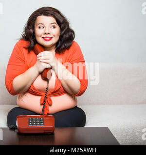Ritratto di un felice donna grassa con telefono Foto Stock