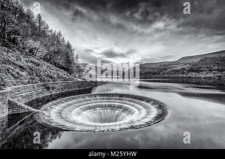 "Scarico" a Ladybower serbatoio del Peak District. Mostra a piena portata su un freddo, nuvoloso giorno. Foto Stock