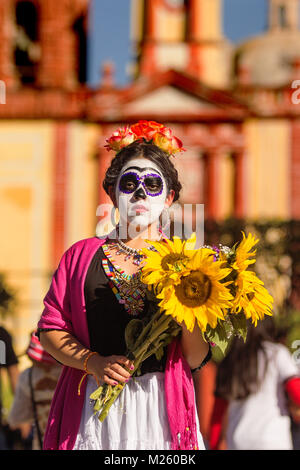 CADEREYTA, Messico - 27 ottobre messicana con catrina trucco e abito Catrina holding girasoli Foto Stock