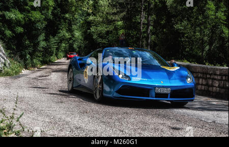 GOLA DEL FURLO, Italia - Ferrari 488 spider 2015 su una vecchia macchina da corsa nel rally Mille Miglia 2017 il famoso storico italiano della gara (1927-1957) a maggio Foto Stock