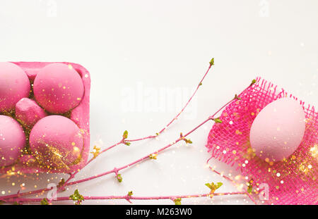 Colore rosa di uova di pasqua nel riquadro rosa, con decorazioni rosa su sfondo bianco; con glitter e spazio copia; uova di pasqua in background Foto Stock