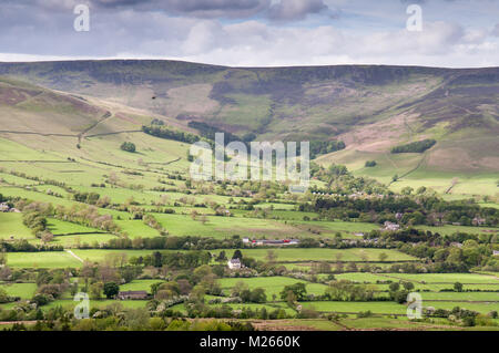 The Moorland altopiano di Kinder Scout si innalza al di sopra del pascoli lussureggianti campi di Edale valley nel Derbyshire, in Inghilterra del Parco Nazionale di Peak District. Foto Stock