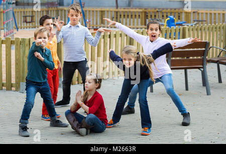 Deliberando gioco con bambini felici rendendo le prestazioni all'aperto in autunno Foto Stock