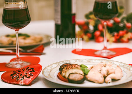 Cena romantica per due con il vino, cuore, fiori Foto Stock