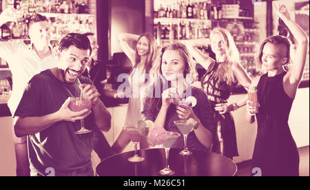 Felice l'uomo con la donna stanno bevendo un cocktail sulla corporate partito. Foto Stock