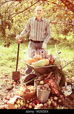 Uomo con verdure raccolto in giardino Foto Stock