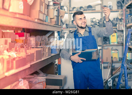 Lavoratore americano controllo piccoli dettagli per ingegneria sanitaria in officina Foto Stock