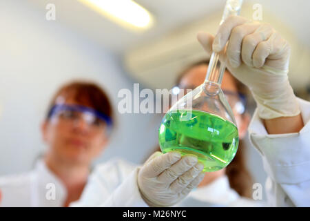 Laboratorio chimico uomo manipolare alcuni palloni Foto Stock