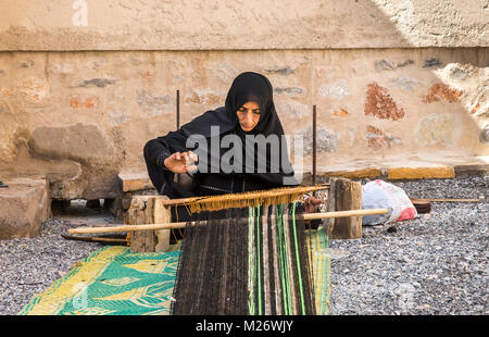 Nizwa, Oman, febbraio 2nd, 2018: omani weawing donna un tappeto Foto Stock