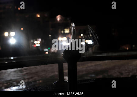 Acqua minerale tiepida continuamente in esecuzione da un rubinetto di giorno e di notte nella parte anteriore dei bagni minerali edificio nella città di Sofia capitale della Bulgaria. fontanella Foto Stock