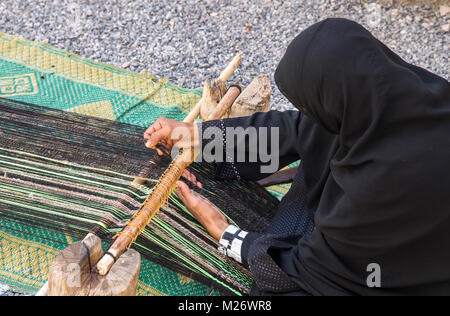 Nizwa, Oman, febbraio 2nd, 2018: omani weawing donna un tappeto Foto Stock