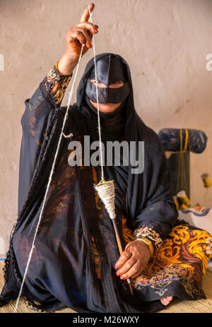 Nizwa, Oman, febbraio 2nd, 2018: omani donna la filatura di un filato Foto Stock