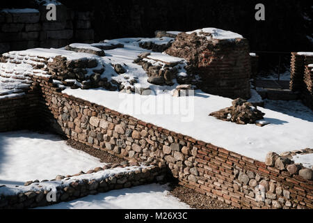 La neve copre resti della porta occidentale della città romana, Serdica, che un tempo occupava questa zona e sono stati scoperti dal 2010 al 2012 durante la costruzione della metropolitana nella città di Sofia capitale della Bulgaria. Foto Stock