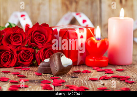 Candele per il giorno di San Valentino sul tavolo di legno su sfondo rosso  Foto stock - Alamy