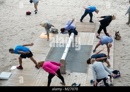 Gli anziani mantenendo montare sulla Spiaggia di Benidorm, Spagna. Uomini donne - pensionati, anziani classe fitness Foto Stock