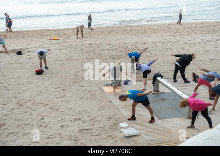 Gli anziani mantenendo montare sulla Spiaggia di Benidorm, Spagna. Uomini donne - pensionati, anziani classe fitness Foto Stock