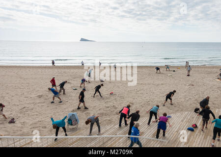 Gli anziani mantenendo montare sulla Spiaggia di Benidorm, Spagna. Uomini donne - pensionati, anziani classe fitness Foto Stock