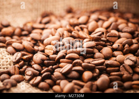 Basso angolo vista di caffè torrefatto in grani grossolani sulla stoffa di iuta. Foto Stock