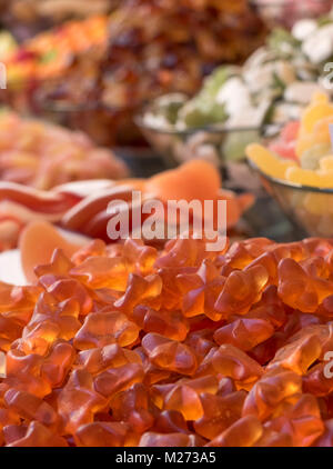 Close up di soft frutta di arancia canditi. Le caramelle sono impilati su un piedistallo e avere diverse forme. In background altre caramelle di differenti col Foto Stock