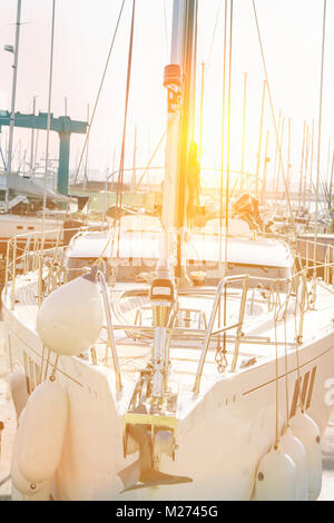 Grandi nuovi bellissimi yacht ormeggiati in banchina sul Mare Mediterraneo. Vista frontale della barca Bow naso. Altezza montante in oro brillante luce del sole. Ariosi Li atmosferica Foto Stock