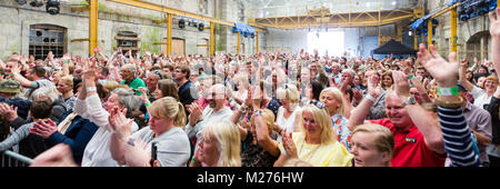 Un pubblico applaude con entusiasmo alla fine di una performance musicale da Seth Lakeman. Foto Stock