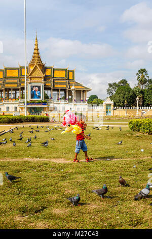 Local ragazzo cambogiano vendita di palloncini da Palazzo Reale e Pagoda d'argento in Royal Palace Park, Phnom Penh, città capitale della Cambogia, SE Asia Foto Stock