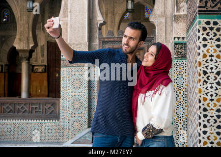 Arab Coppia sorridente e tenendo selfie con telefono mobile Foto Stock