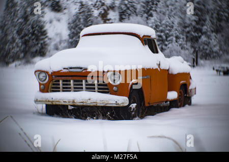 Un arancio 1956 3600 Chevrolet pickup truck in una coperta di neve paesaggio vicino a perma, Montana Foto Stock