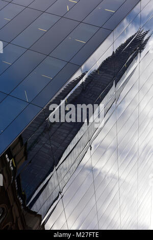 Una diversa o vista insolito dell'iconico Edificio per uffici nel centro di Londra la shard riflessa o riflesso in un altro contemporaneo o blocco moderno. Foto Stock