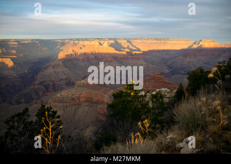 Il sole tramonta oltre il bordo sud del Grand Canyon. Foto Stock