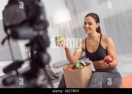 Contenuto blogger parlando di mele durante la realizzazione di un video Foto Stock