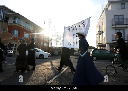 Gli studenti dal Royal Holloway University of London ri-creare un corteo di protesta da suffragettes, in Egham, in occasione del centenario della rappresentanza dei cittadini di agire. Foto Stock