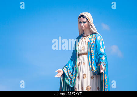 La Beata Vergine Maria statua in piedi nella parte anteriore della diocesi Cattolica Romana con blue sky background in provincia di Chanthaburi, Thailandia. Foto Stock