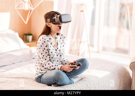 Gioiosa merry donna combattimenti nel gioco VR Foto Stock