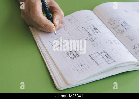 Architetto opere schizzi di disegno sul notebook su sfondo verde Foto Stock