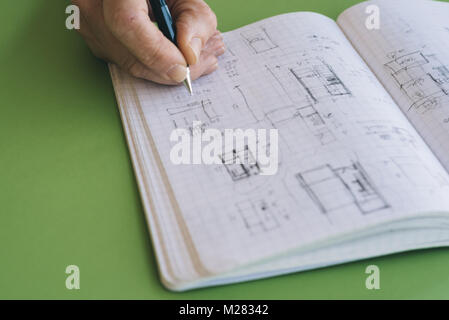 Architetto opere schizzi di disegno sul notebook su sfondo verde Foto Stock