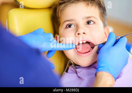 Il dentista controllo della dentatura del ragazzo adolescente. Foto Stock