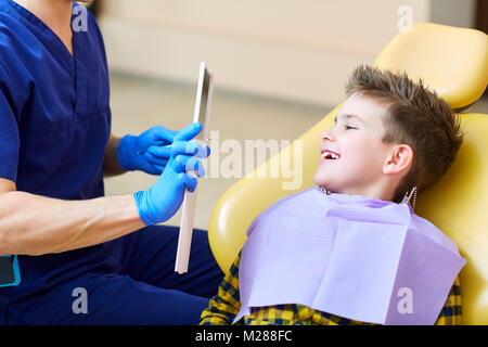 Il dentista controllo della dentatura del ragazzo adolescente. Foto Stock