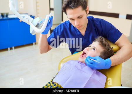 Il dentista controllo della dentatura del ragazzo adolescente. Foto Stock