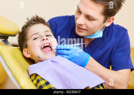 Il dentista controllo della dentatura del ragazzo adolescente. Foto Stock