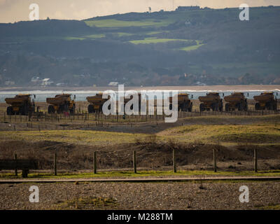 Convoglio di autocarri con cassone ribaltabile sulla costa di segale di scandole in movimento Foto Stock