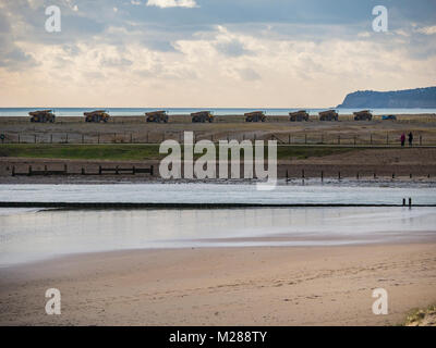Convoglio di autocarri con cassone ribaltabile sulla costa di segale di scandole in movimento Foto Stock