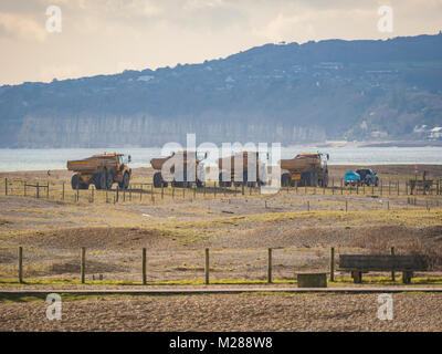 Convoglio di autocarri con cassone ribaltabile sulla costa di segale di scandole in movimento Foto Stock