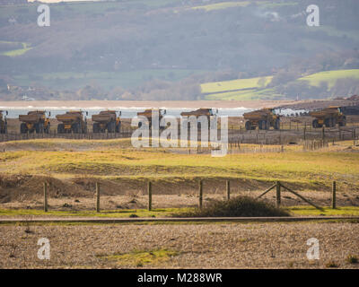Convoglio di autocarri con cassone ribaltabile sulla costa di segale di scandole in movimento Foto Stock