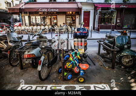 Parigi due ruote parcheggio in strada - SCOOTER, adulti e bambini biciclette nei pressi di un Cafe - Via Parigi - PARIS CAFE - Francia © Frédéric BEAUMONT Foto Stock