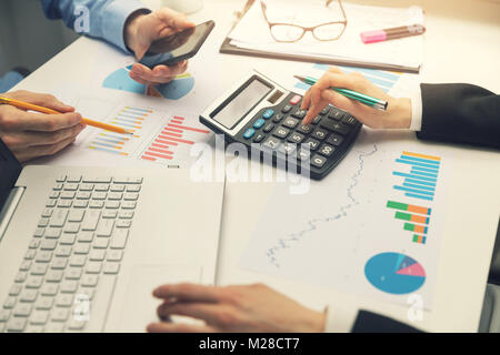 Il team Aziende che lavorano in ufficio con grafici finanziari e grafici Foto Stock